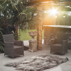 Outdoor photoshoot of sheepskin quad on ground with patio furniture